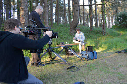 Filming a man drawing on a bench at Pembrey